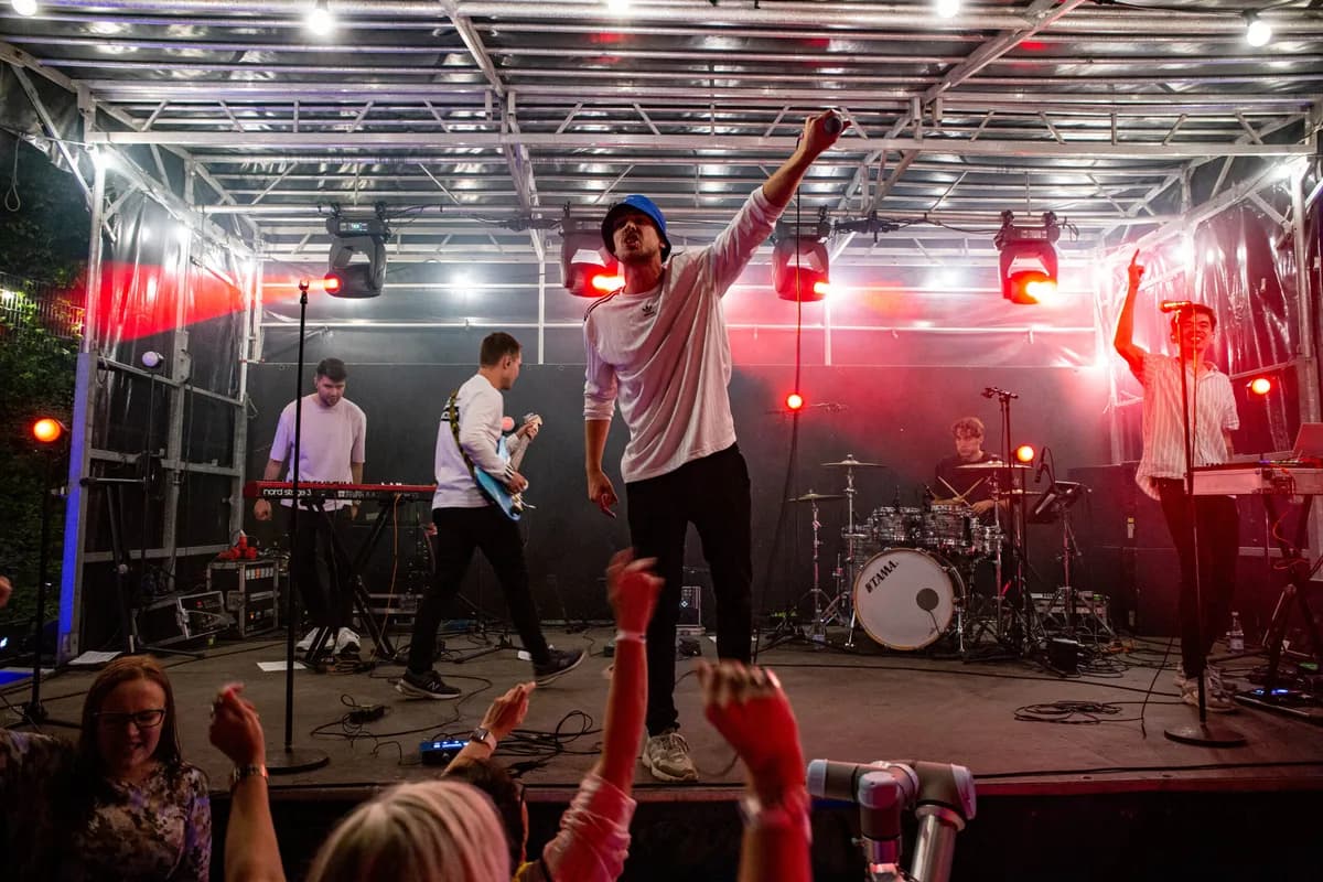 Band på scenen i rødt lys med publikum foran