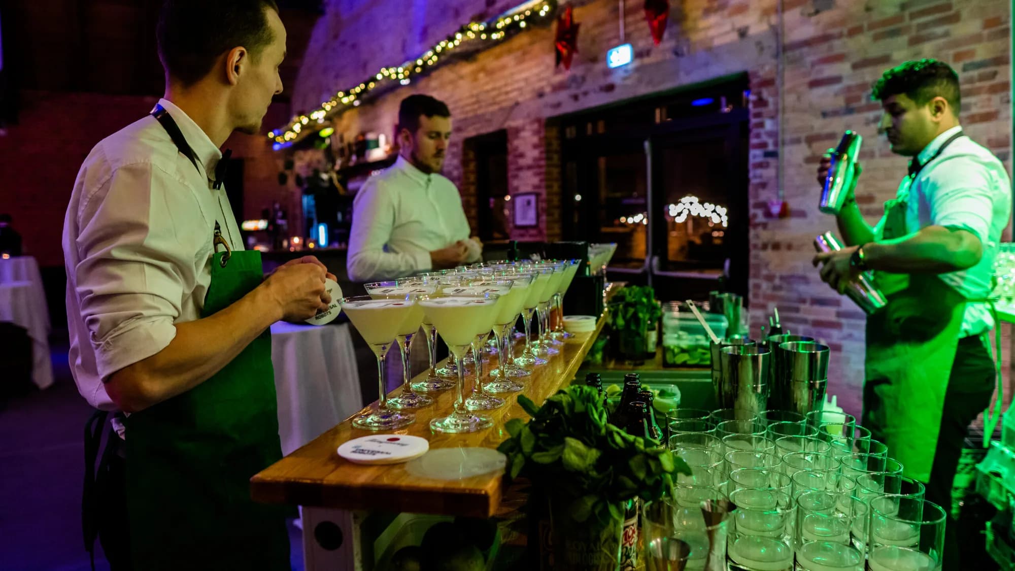 Tre bartendere gør en lang række cocktails klar