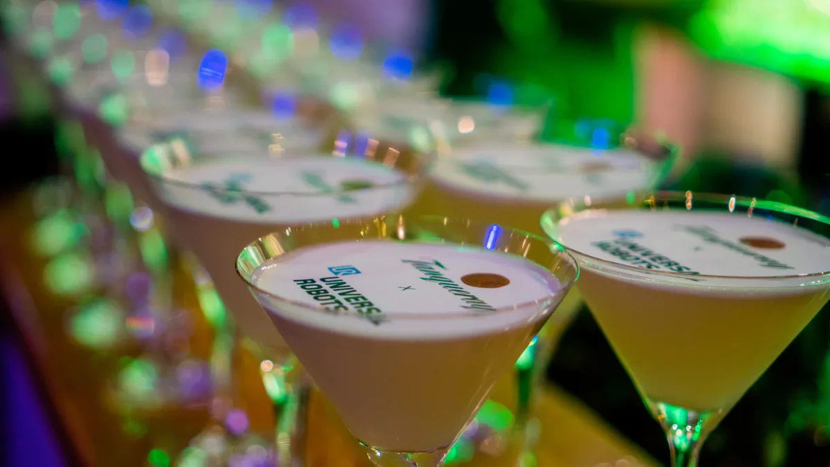 Cocktails med trykt logo på skummet, stillet på række på baren