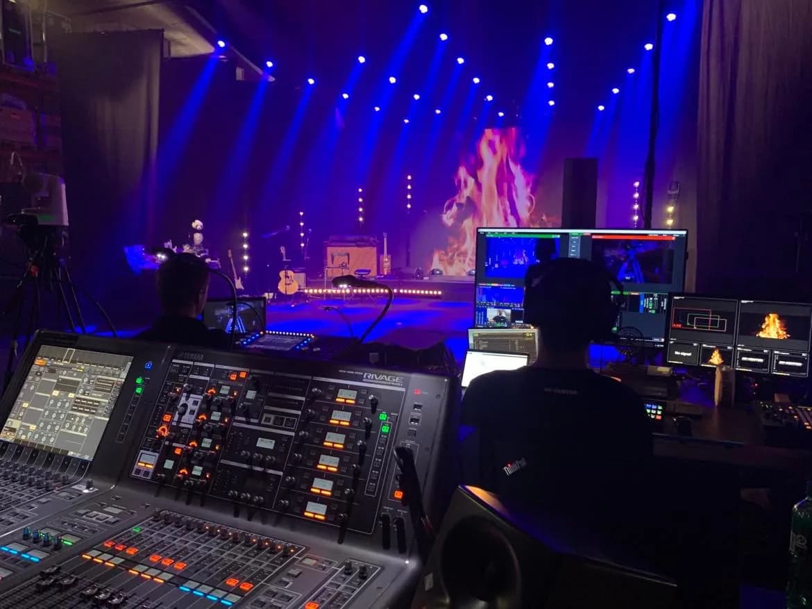 Lydpult set bagfra med scenen i blåt lys