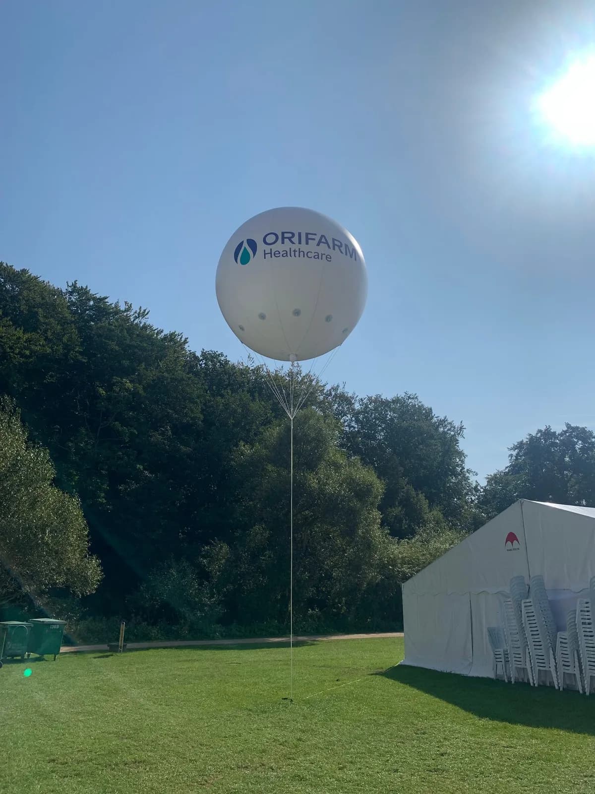 Stor hvid reklameballon over et telt på en græsplæne