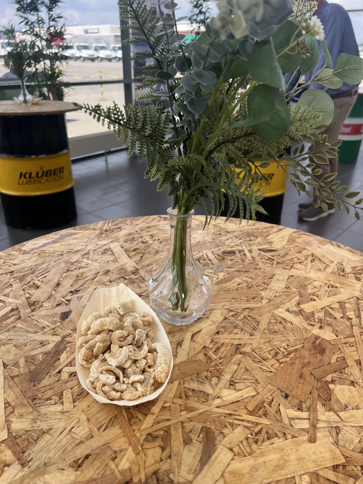 Ståbord med grønne grene og en skål snacks