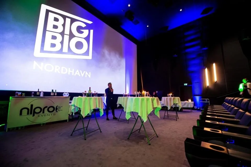 Ståborde med gule duge foran lærredet i en biografsal