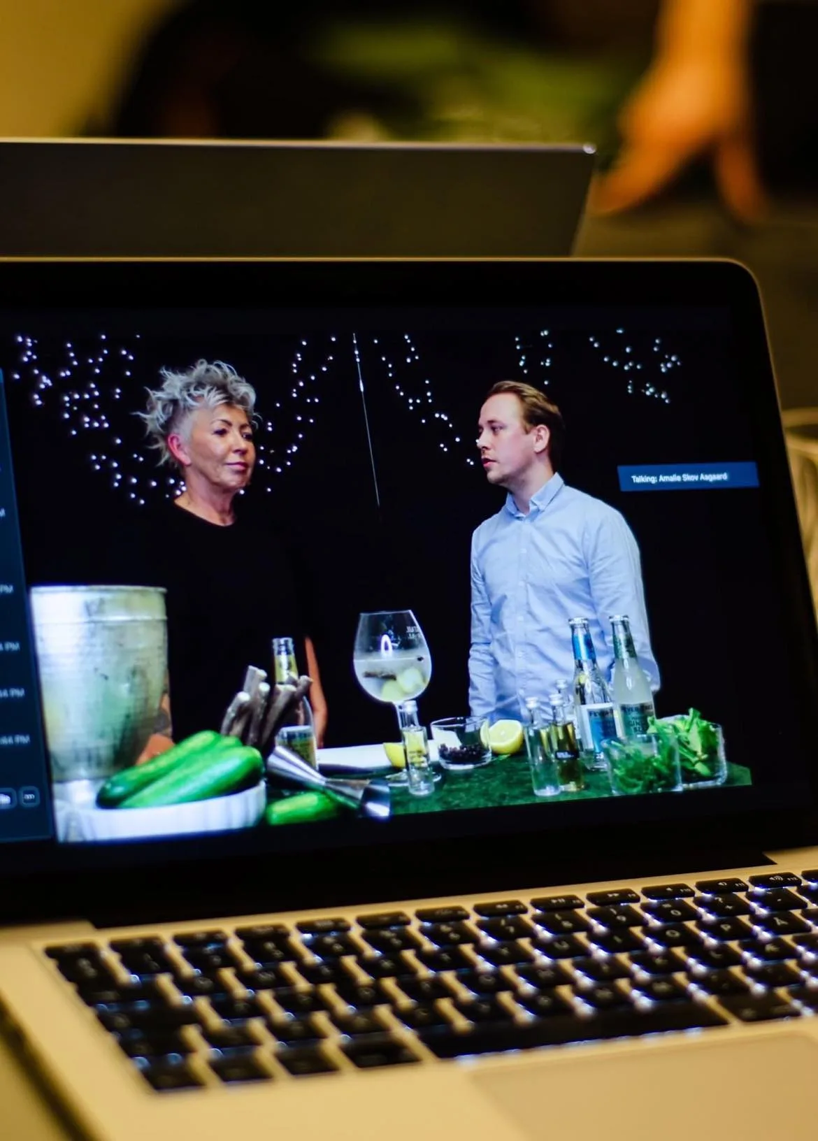 Bærbar computer med redigeringsprogram foran et opstillet studie til en livestreaming